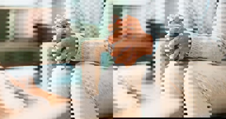 image of a person sitting with hands clasped together