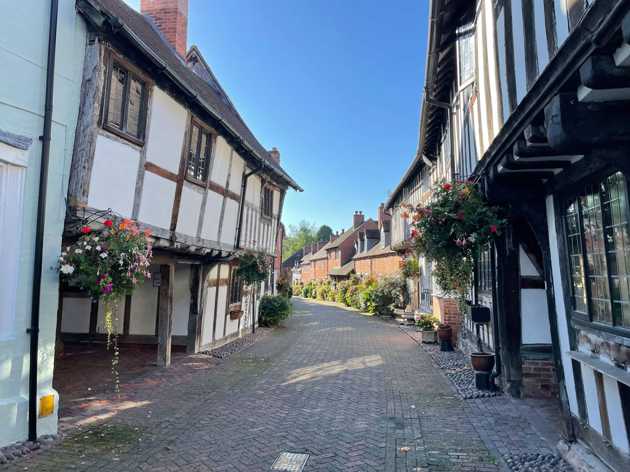 Narrow road with white and black houses on either side