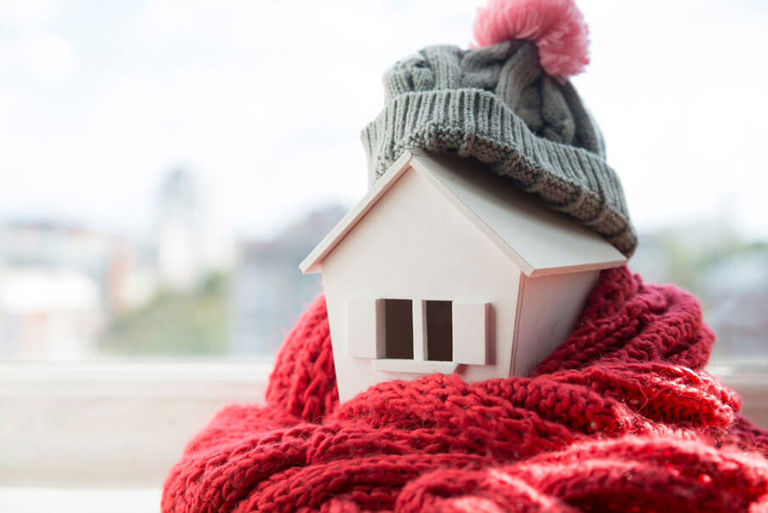 wooden house wrapped in woolen scarf