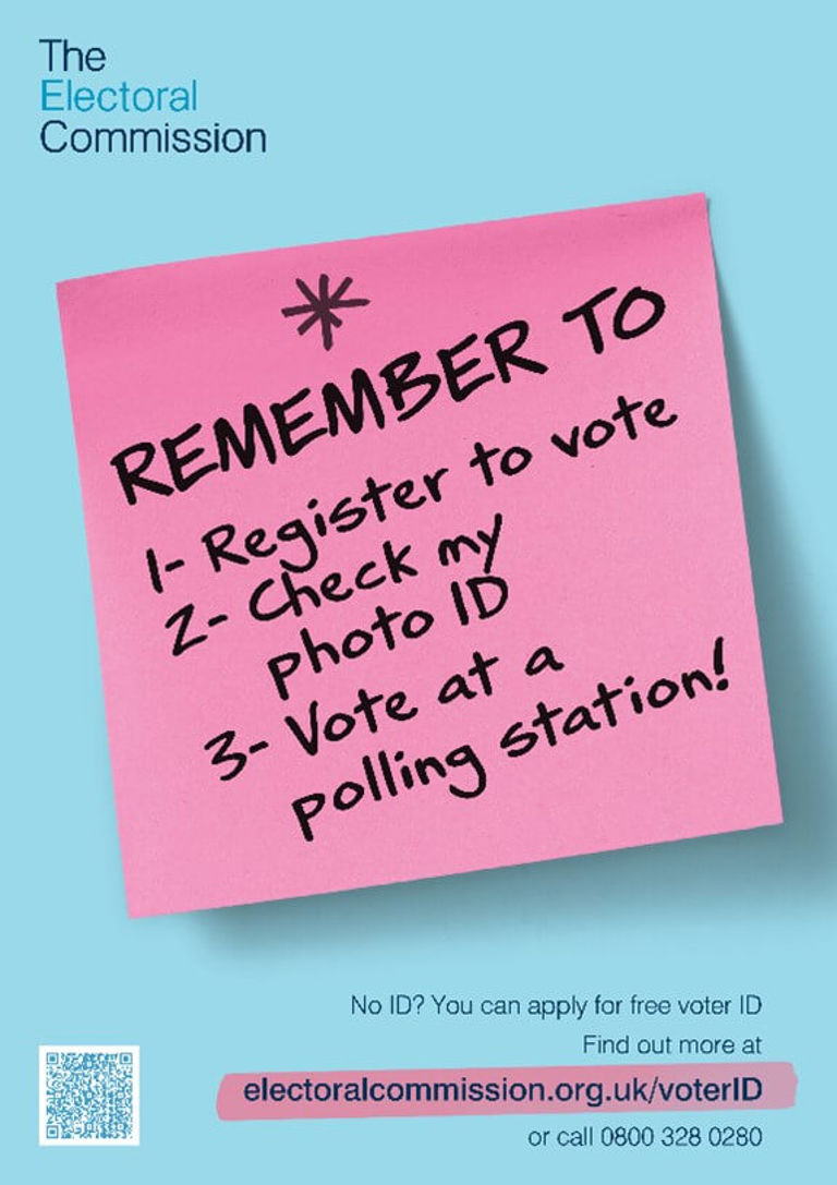 pink post it on blue background with remember to vote written in black marker