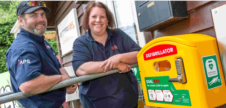 a man and woman standing next to a defibrillator