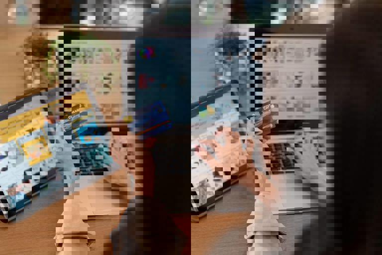 woman on laptop paying for items with bank card