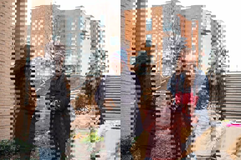 three ladies and a girl standing outside talking