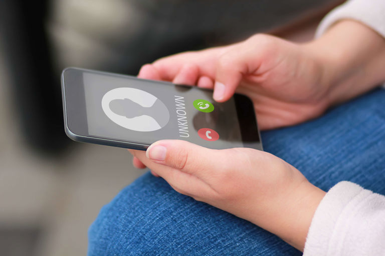 hands holding a mobile phone going to answer or decline a call